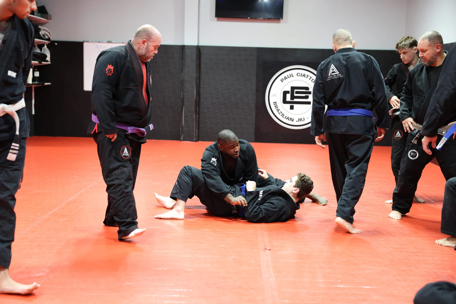 A group learning and practicing Brazilian Jiu-Jitsu at Altus
