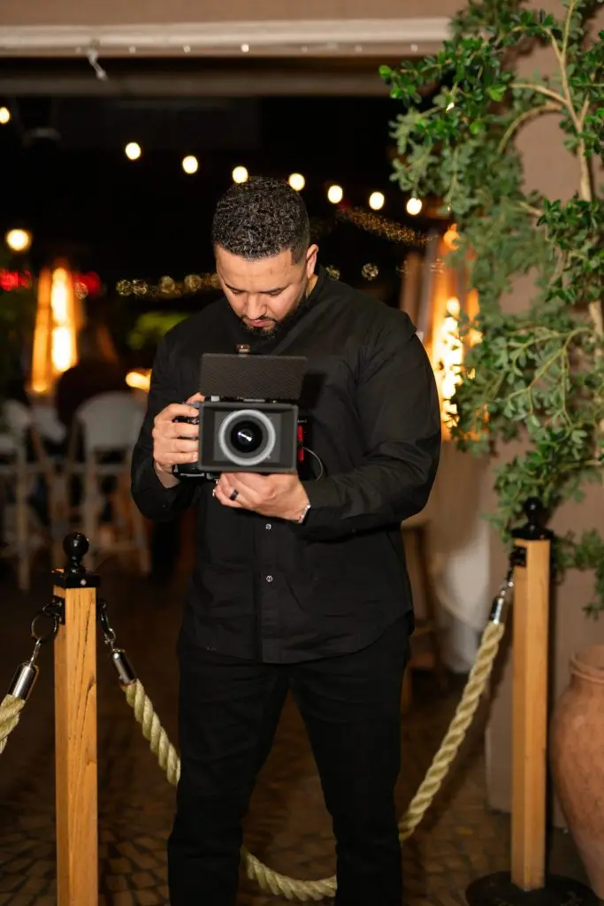 Luis Rivera filming with a cinema camera at an event