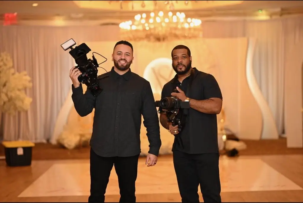 Two members of the production crew holding camera equipment